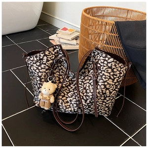 Detail view of large leopard print tote bag featuring a cute fashion bear charm