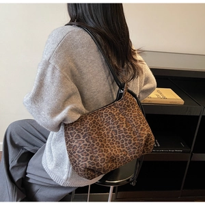 Detail of vintage leopard print shoulder bag featuring dense texture and black strap