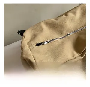 Detailed close-up of silver metal zipper and khaki canvas texture on minimalist tote bag
