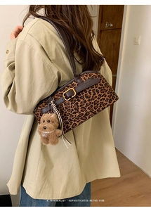 Dettaglio borsa leopardata con fibbia dorata e ciondolo a forma di orsetto