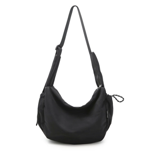 Dettaglio borsa hobo nera con tracolla regolabile ed etichetta laterale del brand