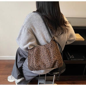 Detail of hobo shoulder bag with leopard print canvas and slim black leather strap