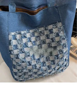 Vue détaillée du grand sac cabas en denim bleu avec patchwork à carreaux et bords effilochés