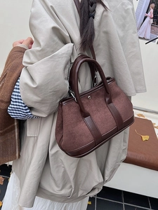 Vintage dark brown suede tote bag with leather trim worn by a model in a fall setting