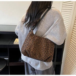 Fashionable leopard print shoulder bag worn by model showing side profile and slim strap