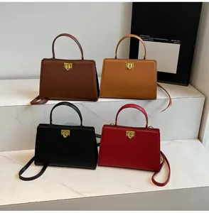Détail de sacs à main rétro en cuir marron, noir et rouge avec fermoirs en U dorés