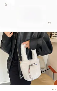 Detailansicht der weißen Plüschtasche aus Kunstpelz mit goldener Kette und gewebtem Riemen
