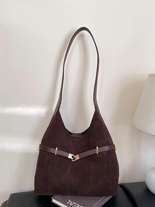 Large brown suede tote bag with vintage metal buckle shown in minimalist interior