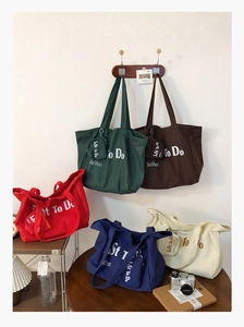 Five assorted canvas tote bags with matching zipper pouches in a lifestyle home setting