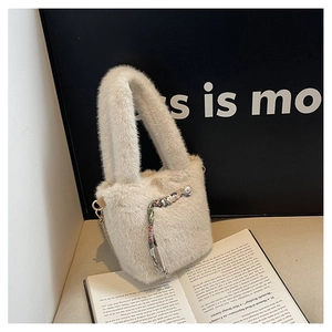 Detailaufnahme der beigen Kunstpelztasche mit Perlenanhängern und goldener Kette