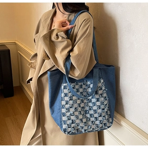 Vue détaillée du grand sac cabas en jean à carreaux porté par un mannequin en trench-coat