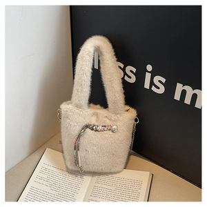 Detailansicht der beigen Plüsch-Beuteltasche mit Perlenanhänger und goldener Kette