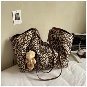 Detailed shot of leopard print tote bag with brown straps and cute bear charm pendant