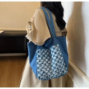Vue détaillée du sac cabas en jean à carreaux bleus avec bordures effilochées sur modèle