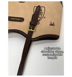 Detail of adjustable leather strap with gold metal buckle on a beige vintage tote bag