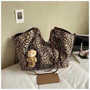 Leopard print tote bag detail with brown faux leather straps and cute plush bear charm