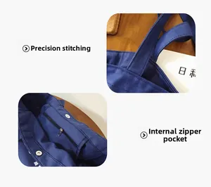 Detail of reinforced stitching and inner zipper pocket on dark blue canvas tote bag