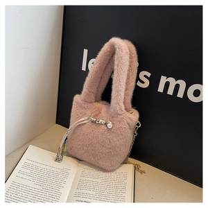 Detailansicht der rosa Kunstfelltasche mit Goldkette und dekorativem Perlen-Seidenschal