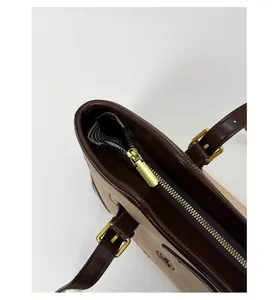 Detail of premium golden metal zipper and striped lining on beige leather tote bag