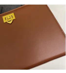 Détail d'un sac à main en cuir marron avec un fermoir métallique doré de qualité