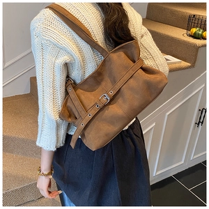 Gros plan d'un grand sac cabas en daim marron foncé avec détail de boucle réglable