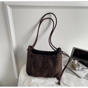 Fashionable leopard print shoulder bag displayed with a laptop and a headset
