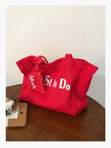 Detail of red canvas tote bag and mini zipper pouch with white Just to Do lettering