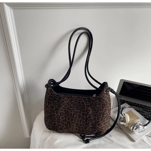 Close-up of leopard print shoulder bag featuring suede texture and side drawstring details