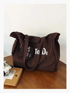 Close-up of dark brown canvas tote bag and matching pouch with To Do white lettering
