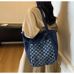 Vue détaillée du sac cabas en denim à motif damier et bords effilochés porté par modèle