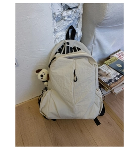 Mochila color crema resistente al agua con colgante de cachorro de felpa en interiores