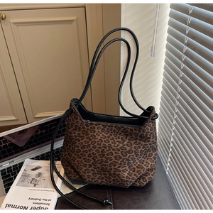 Macro detail of vintage leopard print handbag texture with sleek black thin straps