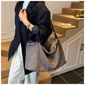 Deep grey canvas tote bag with leather straps and vintage beaded charm for office wear