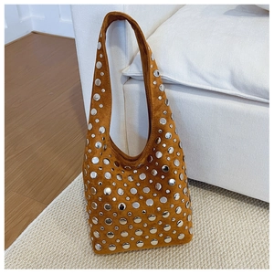 Détail du sac seau en daim caramel orné de clous métalliques argentés variés
