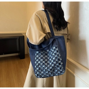 Détail du sac cabas en jean avec patchwork à damier porté à l'épaule du mannequin