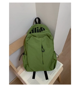 Detalle de mochila verde resistente al agua con bolsillo frontal y cordón elástico lateral