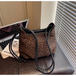 Detailed close-up of a stylish leopard print shoulder bag with black straps and zipper