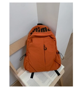 Detalle de la mochila naranja de nailon impermeable con logo y bolsillo lateral de cordón