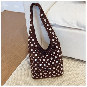Gros plan d'un sac cabas en daim marron avec des rivets métalliques argentés décoratifs