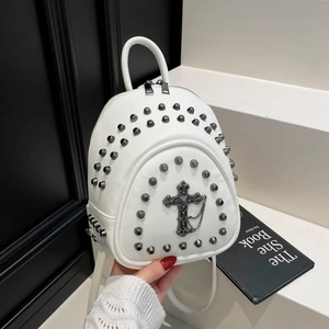 Detail of white leather mini backpack with gothic metal rivets and cross pendant