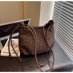 Detail view of leopard print hobo shoulder bag with brown strap on a stylish desk