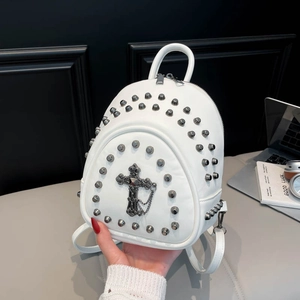 Close-up of white mini rivet backpack with metal cross pendant and punk chain details