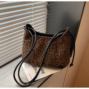 Detail of leopard print suede shoulder bag with black leather straps and texture