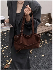Detail of dark brown suede tote bag featuring silver hardware and retro buckle straps