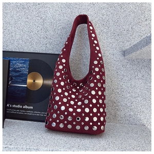 Détail du sac à bandoulière en daim bordeaux orné de disques métalliques argentés