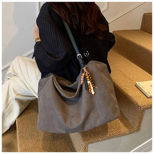 Detail of dark gray canvas tote bag with vintage beaded fringe and slouchy drape style