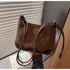 Close-up of leopard print tote bag with brown leather straps in a bright lifestyle setting