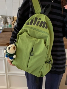 Mochila de nylon verde ligera e impermeable para estudiantes con un bonito colgante de perro