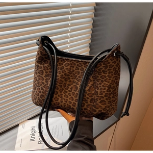 Macro view of leopard print shoulder bag with suede texture and black round straps