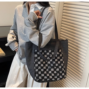 Détail du grand sac cabas en denim à carreaux avec bords effilochés et style décontracté